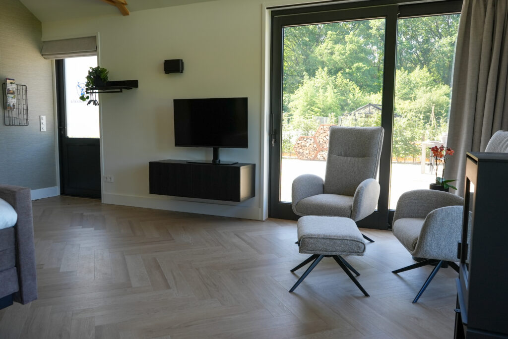 Zithoek met televisie in Bed & Breakfast De Koningshoeve